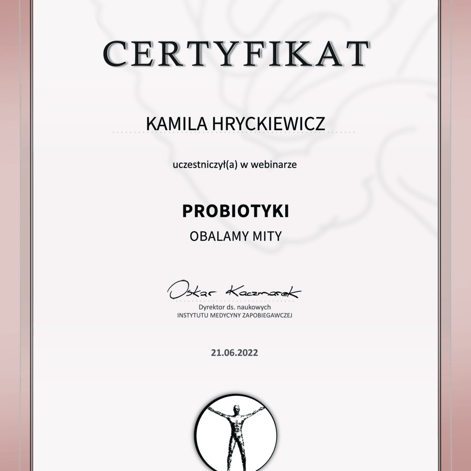 Elegancki certyfikat w odcieniach beżu i brązu, z grubą, ozdobną ramką. Tło dokumentu zdobi subtelny, białawy wzór przypominający zwoje mózgowe. Na środku widnieje tytuł 'CERTYFIKAT'. Potwierdza on, że Kamila Hryckiewicz uczestniczyła w webinarze pt. 'PROBIOTYKI OBALAMY MITY'. Webinar odbył się 21.06.2022. Poniżej znajduje się odręczny podpis Oskara Kaczmarka, Dyrektora ds. naukowych Instytutu Medycyny Zapobiegawczej. Na samym dole certyfikatu umieszczone jest logo Instytutu Medycyny Zapobiegawczej – stylizowana sylwetka człowieka z rozłożonymi rękami, symbolizująca równowagę i zdrowie
